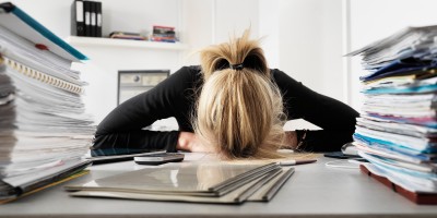 Businesswoman resting head on desk